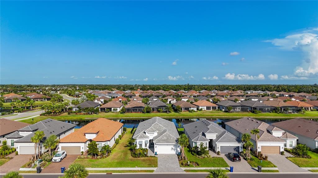 An aerial view of a suburban neighborhood featuring several single-family homes with tiled roofs — 6145 GRANDVIEW HILL COURT, BRADENTON, FL