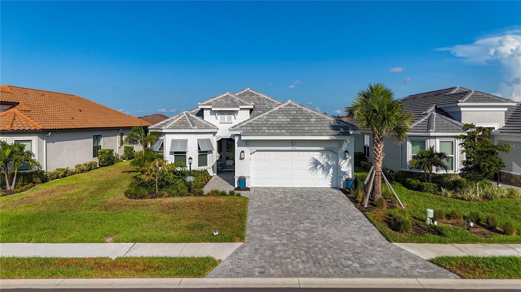 A single-story house with a gray tiled roof, white exterior, and a paved driveway — 6145 GRANDVIEW HILL COURT, BRADENTON, FL