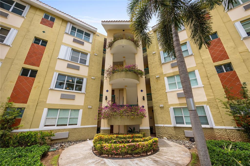 An exterior view of a multi-story apartment building with curved balconies and landscaped garden beds — C-3 CANDELERO ROAD UNIT C-3, HUMACAO, PR