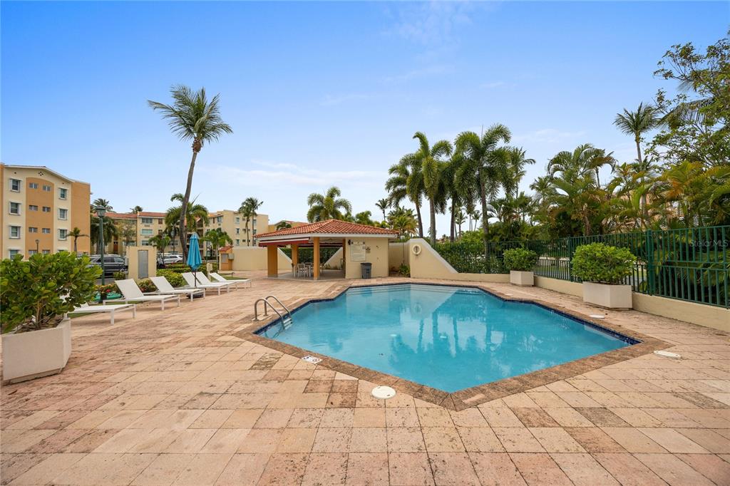 A swimming pool with a tiled deck and a covered pavilion surrounded by palm trees — C-3 CANDELERO ROAD UNIT C-3, HUMACAO, PR