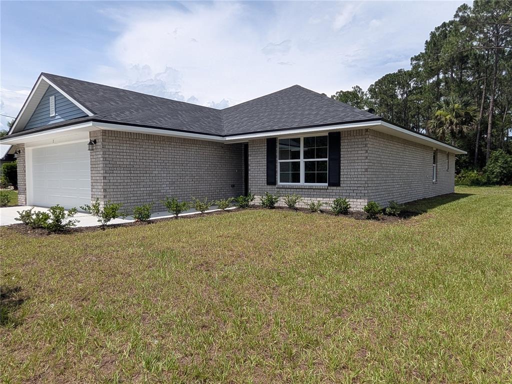 A kitchen with white cabinets, granite countertops, and stainless steel appliances — 7 ULLYNN PLACE, PALM COAST, FL