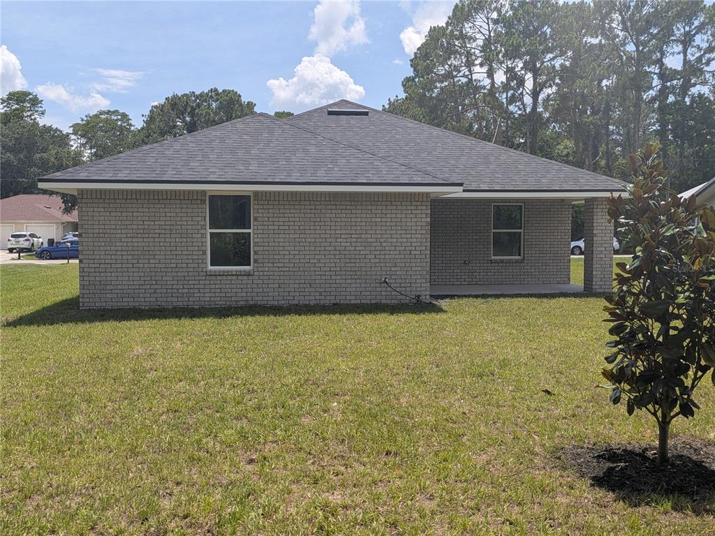 A laundry room features white cabinets, dark wood-look flooring, and multiple white interior doors — 7 ULLYNN PLACE, PALM COAST, FL