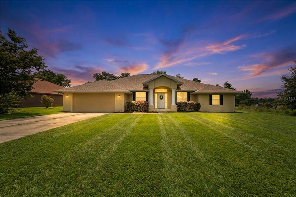 A single-story house with a tan exterior, a two-car garage, and a large front lawn — 5320 SW 115TH LOOP, OCALA, FL