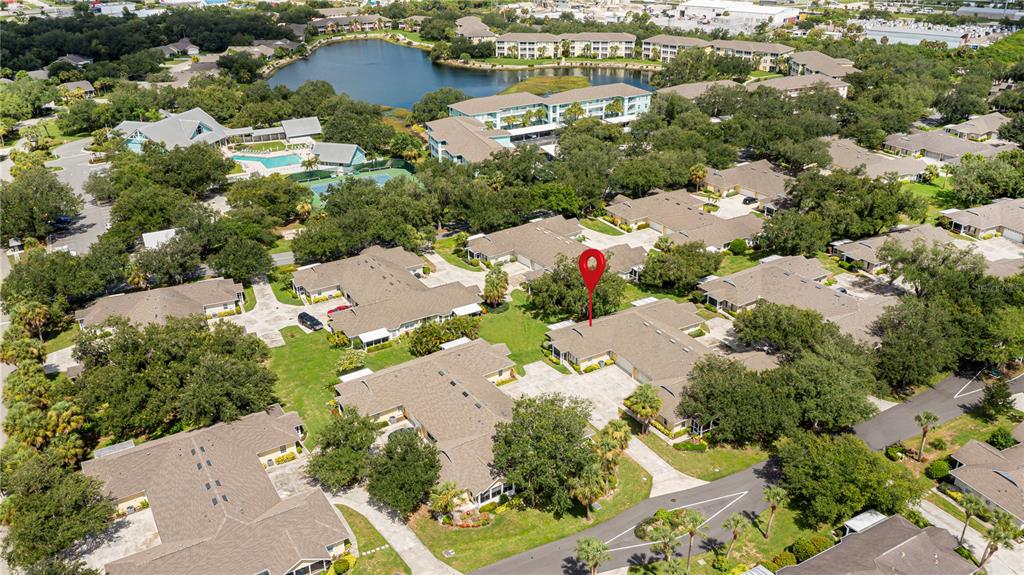 An aerial view shows a residential complex with multiple buildings, a lake, and a red marker — 1554 RED OAK LANE, PORT CHARLOTTE, FL