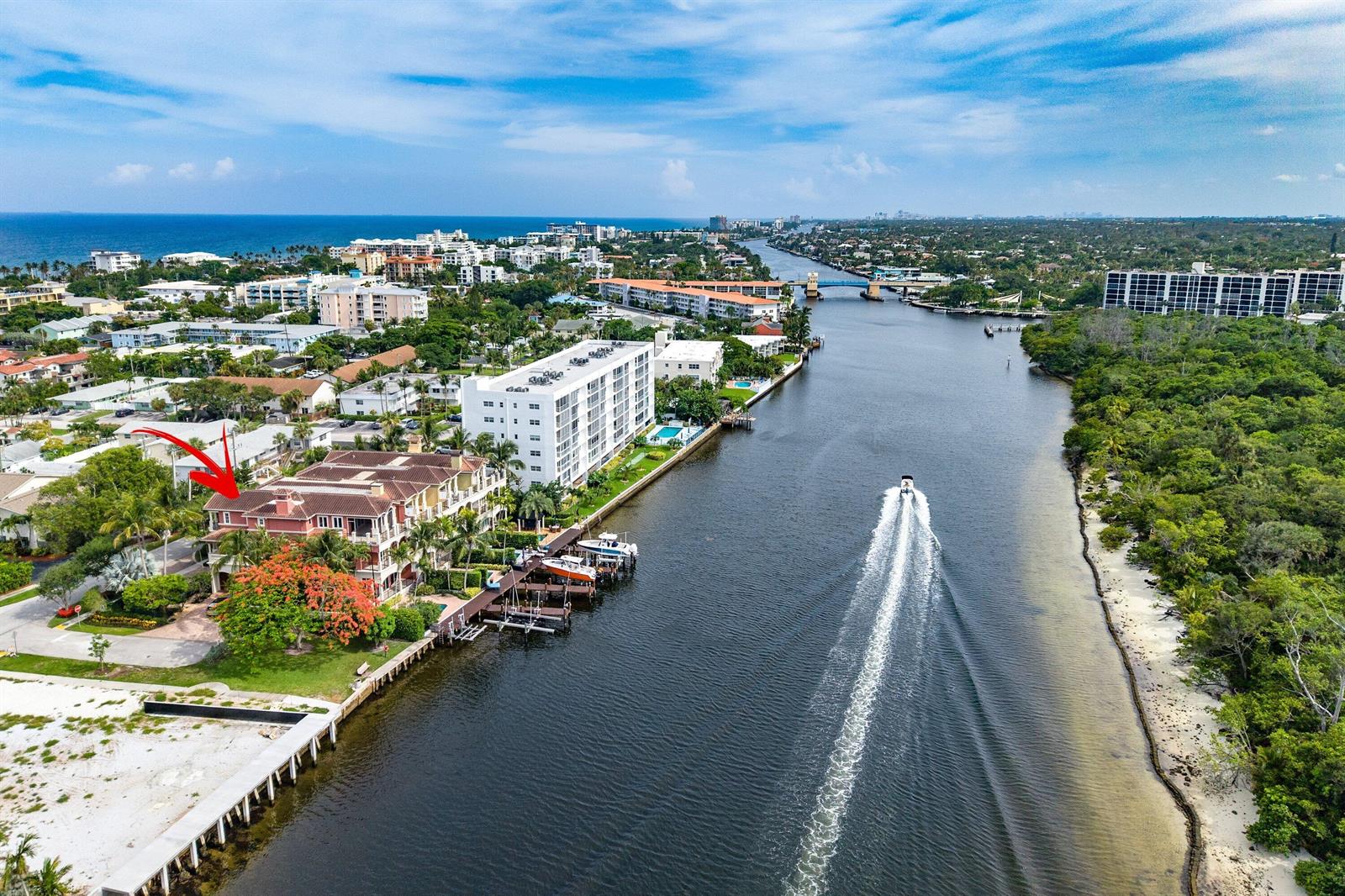 An aerial view shows a waterfront residential building with a red arrow pointing toward it — 453 NE 19th Avenue, Deerfield Beach FL 33441, DEERFIELD BEACH, FL