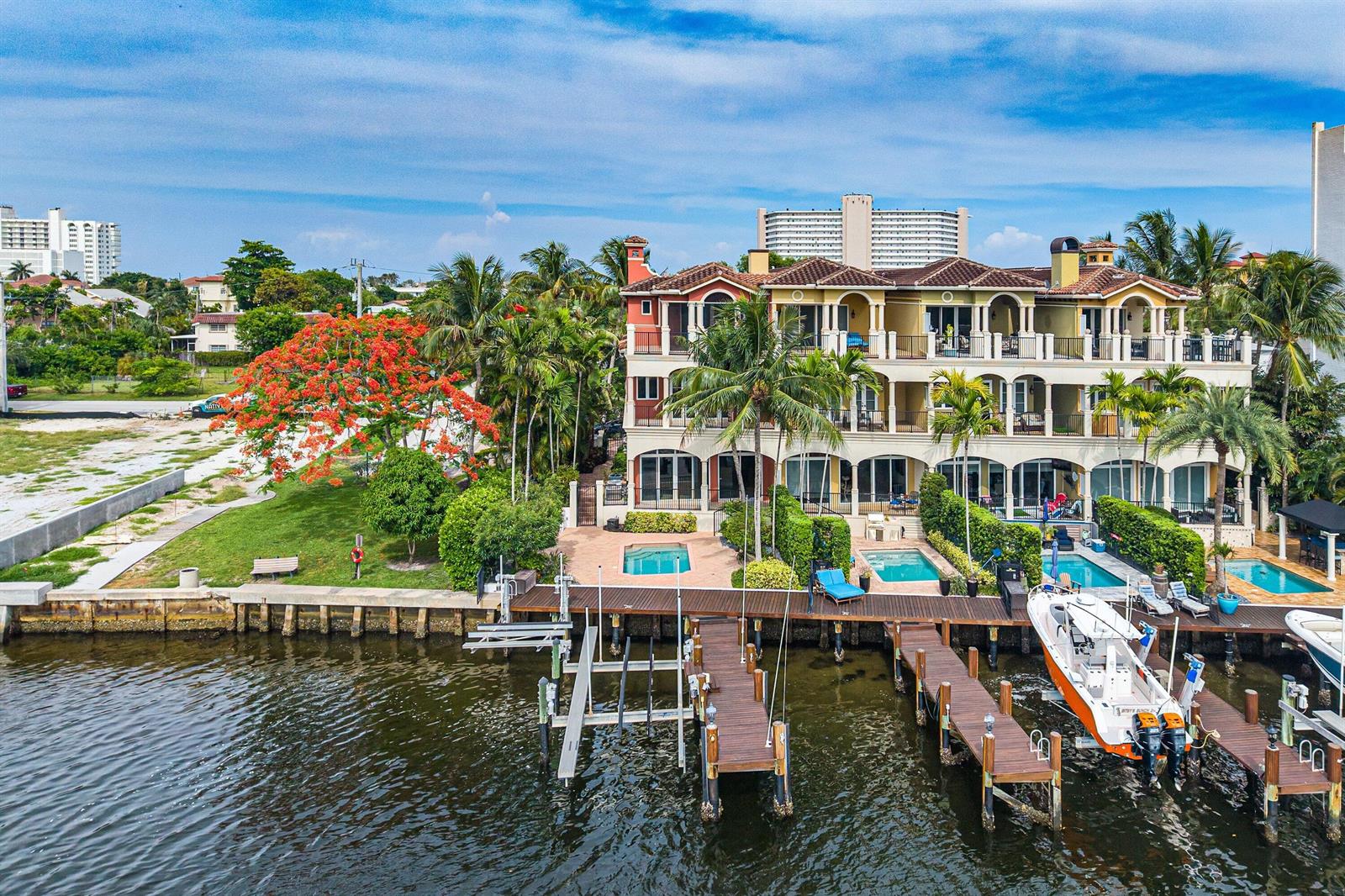 An aerial view of a multi-story waterfront villa with private docks, pools, and palm trees — 453 NE 19th Avenue, Deerfield Beach FL 33441, DEERFIELD BEACH, FL