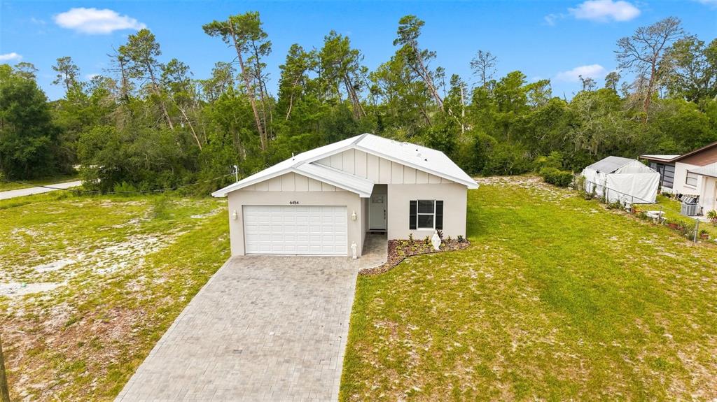 An aerial view of a single-story house with a paved driveway and a white roof — 6454 FREEPORT DRIVE, SPRING HILL, FL