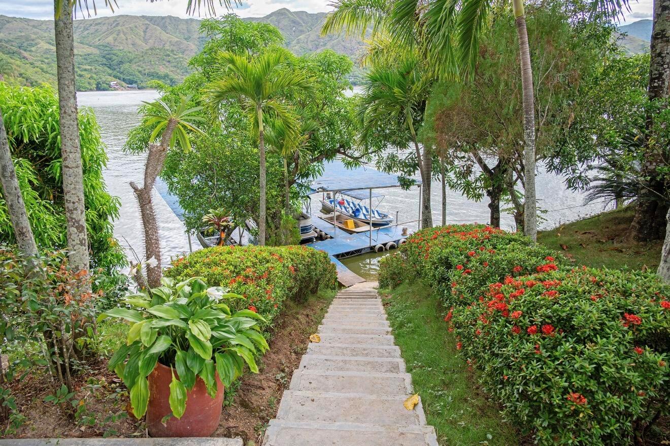 Concrete stairs lead down through a garden to a boat dock on a lake — El Paraiso Del Lago, FL