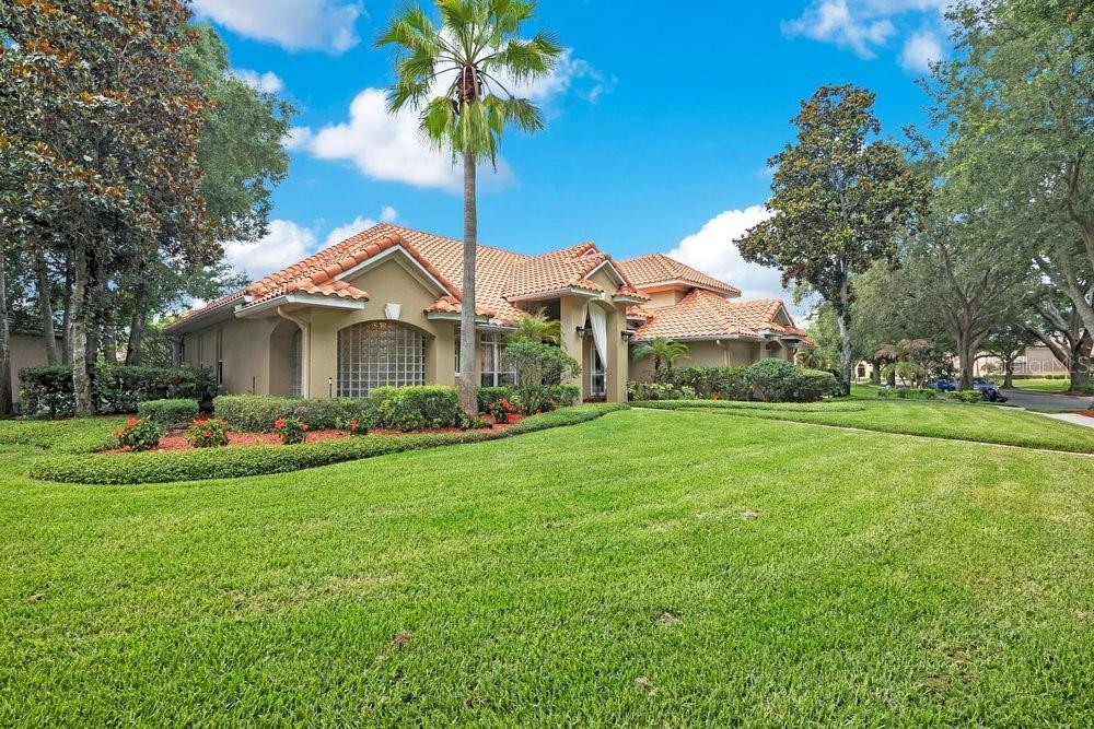 A single-story house with a terracotta tile roof and a palm tree in the front yard — 7718 DEBEAUBIEN DRIVE, ORLANDO, FL