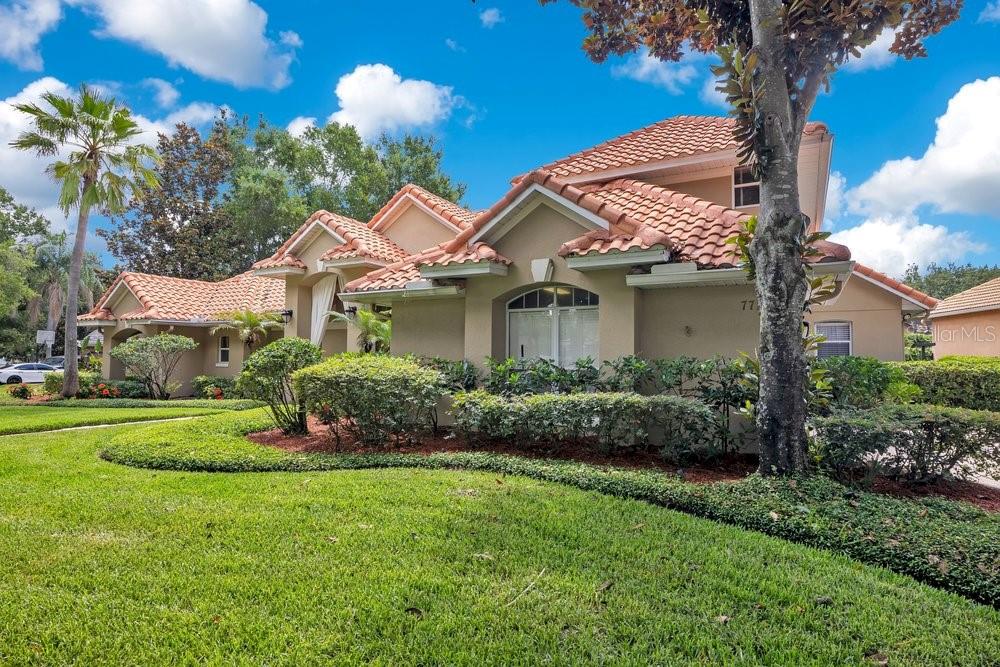 A tan house with a terracotta tile roof and a large front lawn — 7718 DEBEAUBIEN DRIVE, ORLANDO, FL