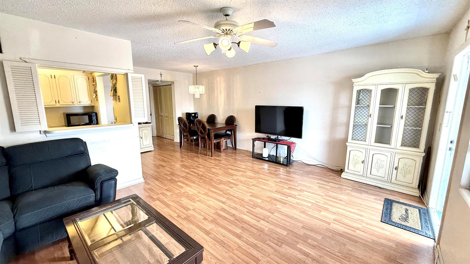 A living room features wood-look flooring, a ceiling fan, a dining area, and a hutch — 122 Oakridge I, Deerfield Beach FL 33442, DEERFIELD BEACH, FL