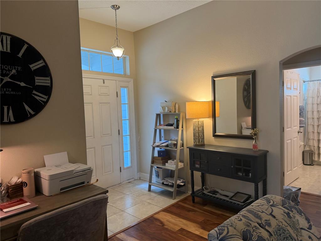An entryway features a tiled floor, a console table with a mirror, and a ladder shelf — 4851 NW 81ST AVENUE, GAINESVILLE, FL