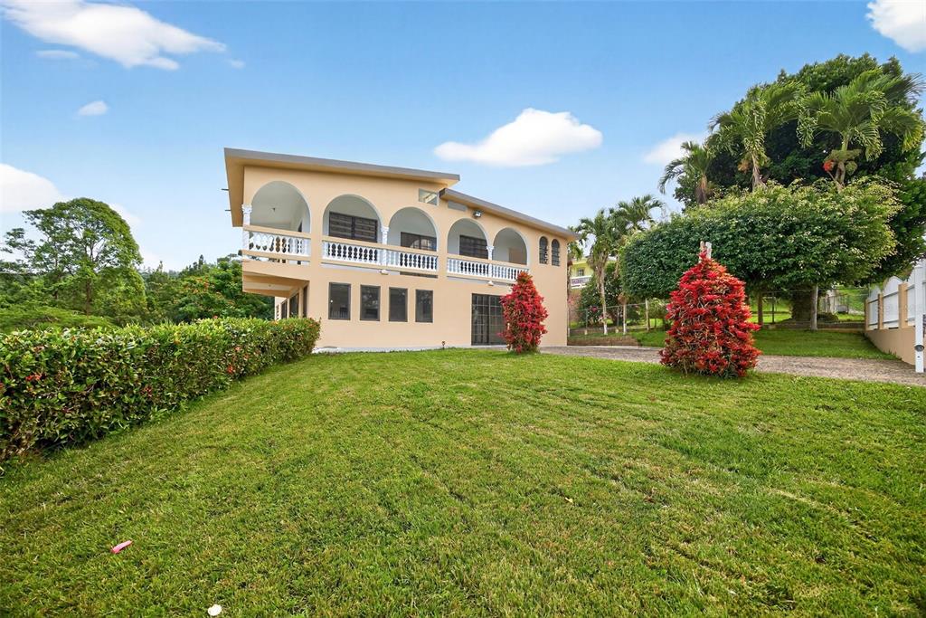 A two-story beige house with arched balconies and a large green lawn — PR-184 KM 32.4 S BEATRIZ, CAYEY, PR