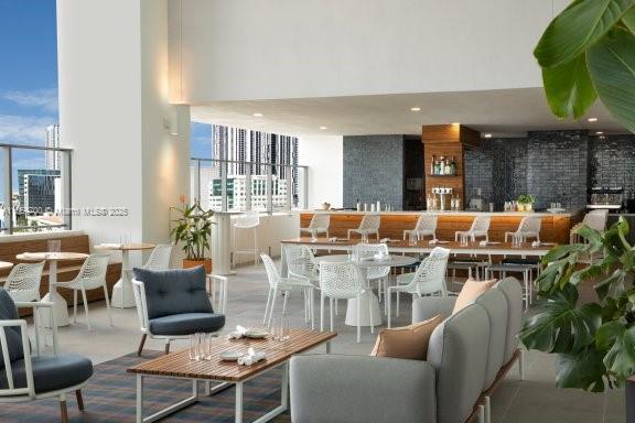 This outdoor terrace features a bar, lounge seating, and dining tables under a covered roof — 227 NE 2nd St # 1707, Miami FL 33132, MIAMI, FL