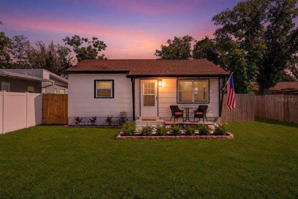 A small white house with a brown roof, a front patio, and a grassy yard — 3766 56TH AVENUE N, ST PETERSBURG, FL