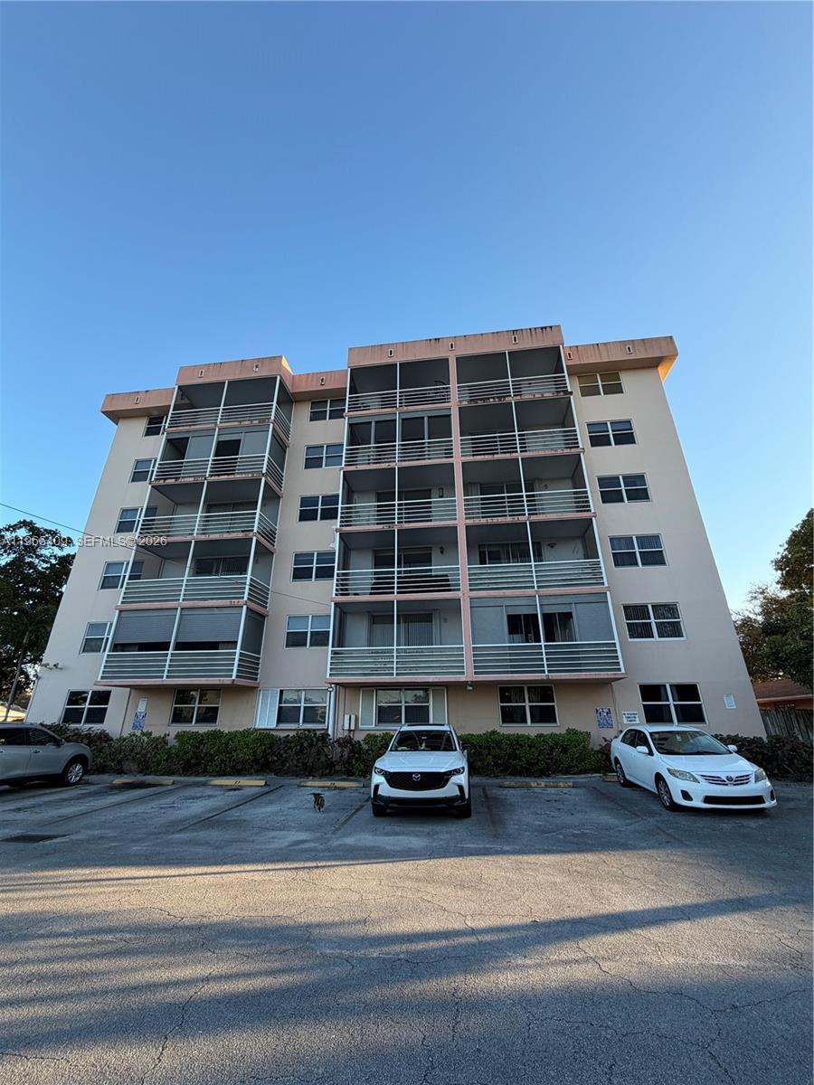 A multi-story apartment building with balconies and a parking lot in front — 1830 Dixieanna St # 406, Hollywood FL 33020, HOLLYWOOD, FL