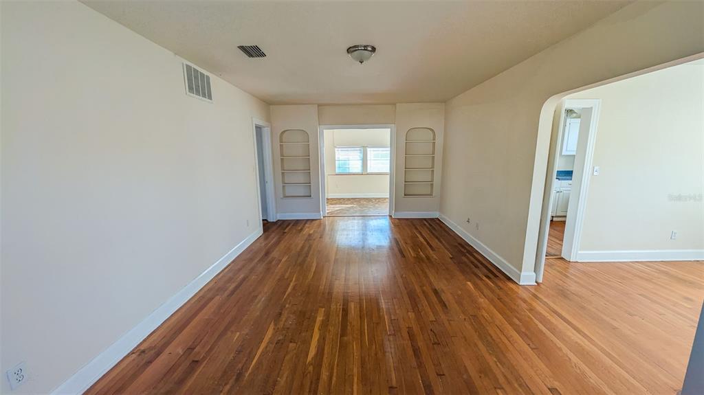 An interior view of a living room with hardwood floors and built-in wall shelving — 860 16TH AVENUE S, ST PETERSBURG, FL