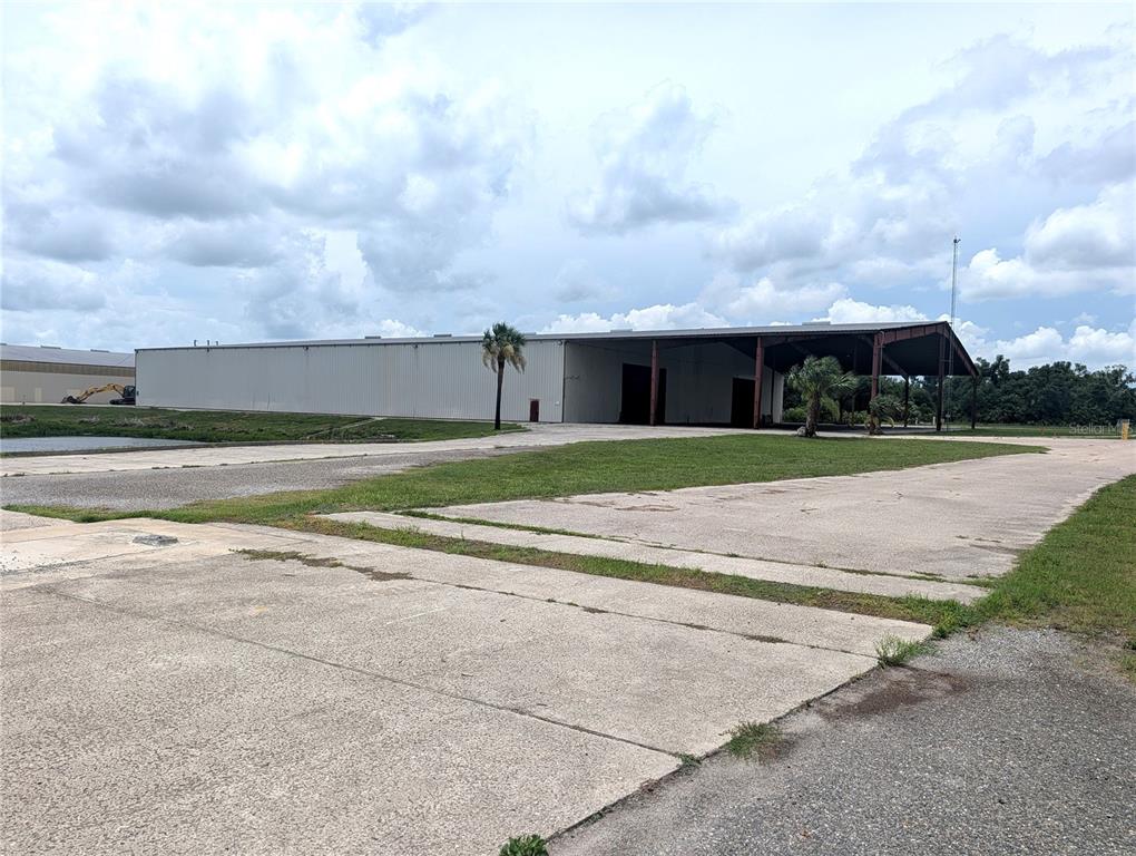 A large metal warehouse building sits on a concrete lot with a grassy area — 1509 S BYRON BUTLER PARKWAY, PERRY, FL