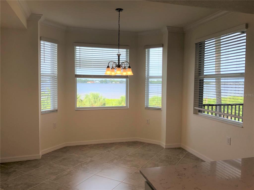 A dining nook with tile floors, a chandelier, and windows overlooking a body of water — 1010 TIDEWATER SHORES LOOP UNIT 206, BRADENTON, FL