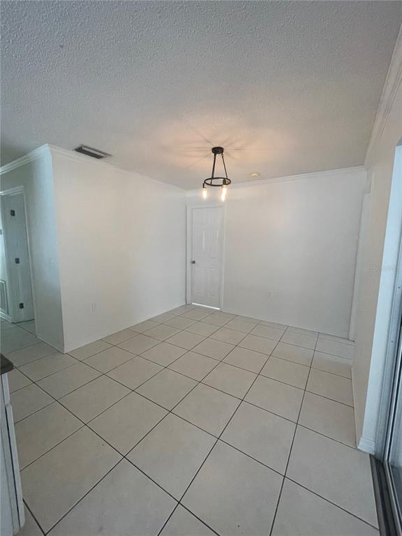 A dining area with white walls, light-colored tile flooring, and a modern circular pendant light — 3021 W TAMPA BAY BOULEVARD, TAMPA, FL