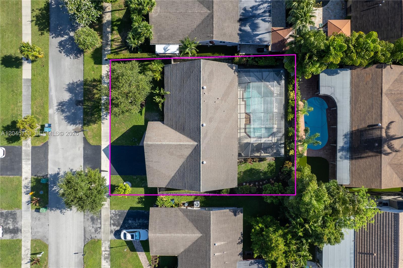 An aerial view shows a house with a screened-in pool and a driveway — MIAMI, FL