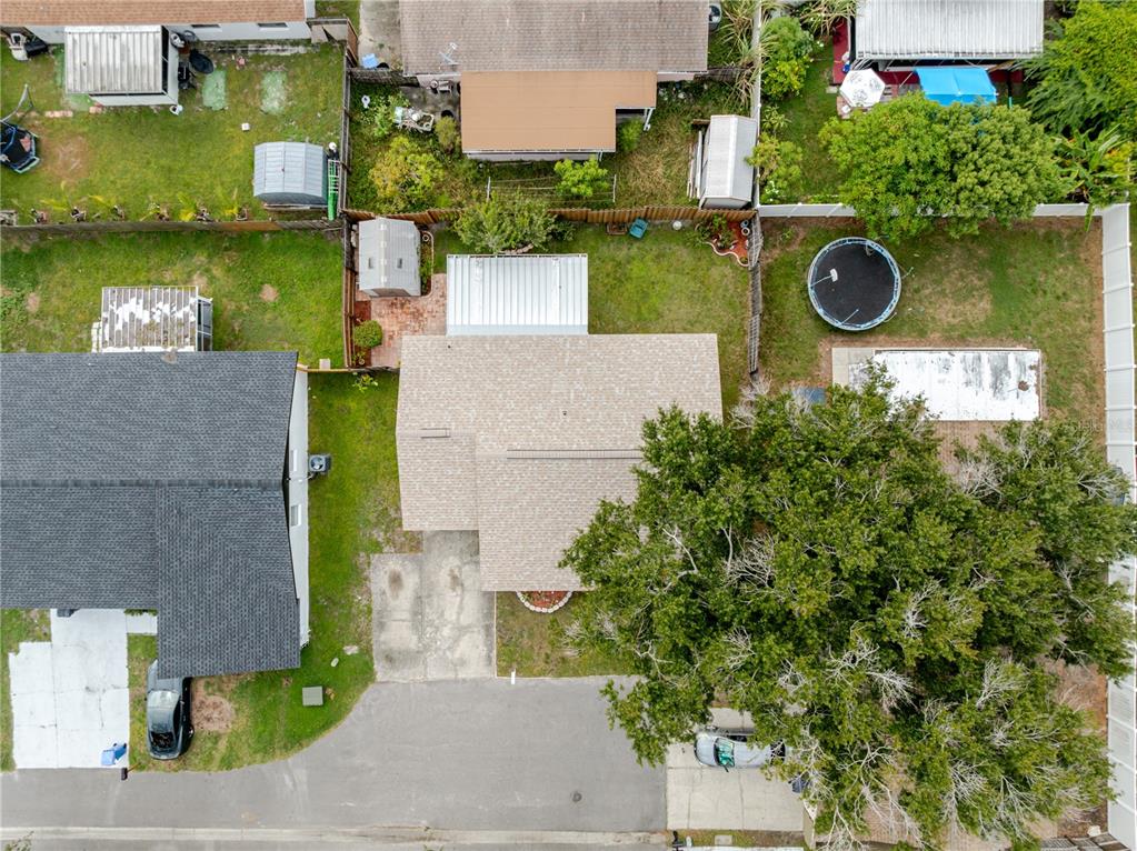 An aerial view shows a residential property with a house, driveway, and backyard with trees — 10118 HUNTERS POINT COURT, TAMPA, FL