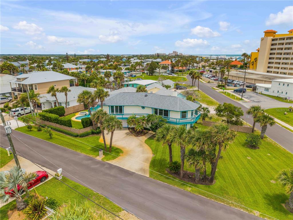 An aerial view shows a two-story house with a wrap-around balcony and a swimming pool — 320 DUE EAST STREET, NEW SMYRNA BEACH, FL