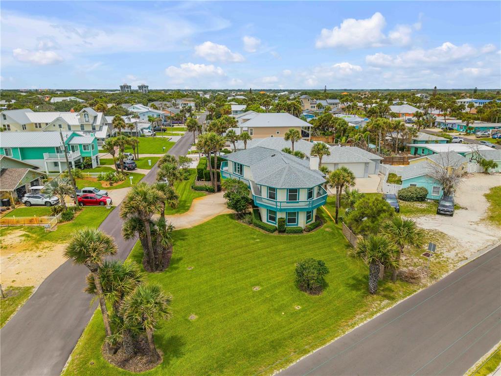 An aerial view shows a two-story teal house with a wrap-around balcony and lawn — 320 DUE EAST STREET, NEW SMYRNA BEACH, FL