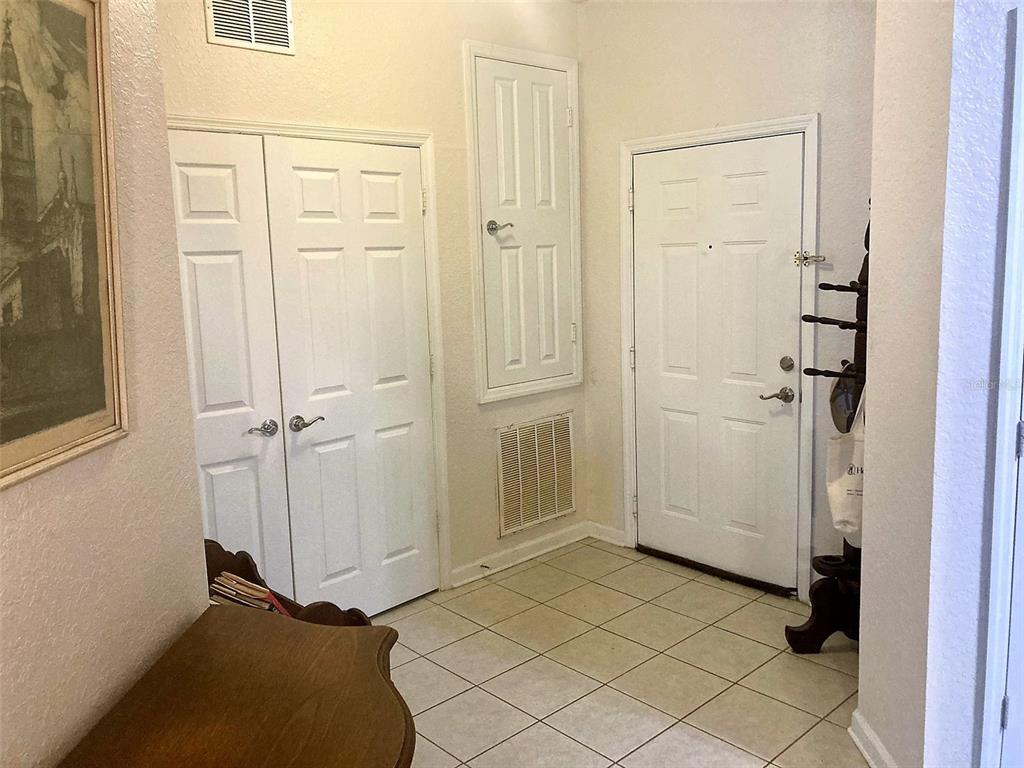An entryway features tiled floors, a white front door, and two sets of white doors — 2484 SAN TECLA STREET UNIT 310, ORLANDO, FL