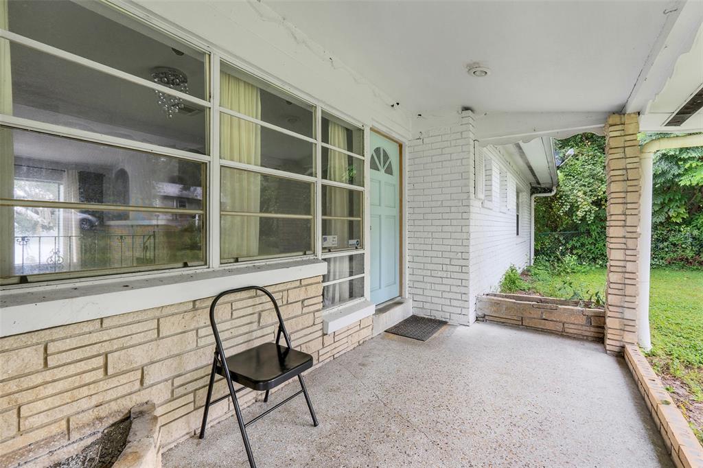 A covered porch features a light blue front door, white brick walls, and stone accents — 1148 PEARL VIEW DRIVE, ALTAMONTE SPRINGS, FL