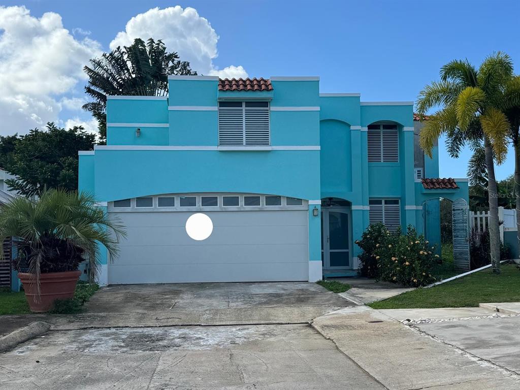 A two-story, bright blue house with a white garage door and a palm tree — CALLE RIO PITAHAYA RIVER EDGE HILLS UNIT 120, LUQUILLO, PR