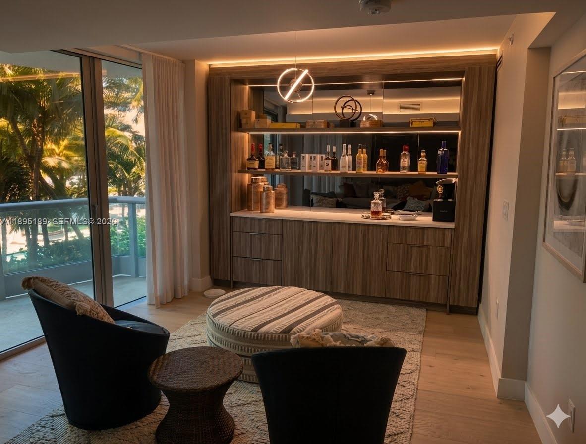 A living room features a sofa, armchairs, a coffee table, and large sliding glass doors — 9401 Collins Ave # 305, Surfside FL 33154, SURFSIDE, FL