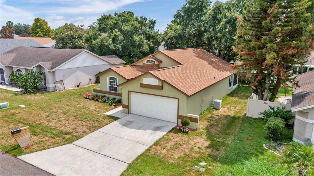 A single-story house with a green exterior, a two-car garage, and a front lawn — 419 SAINT ANNS DRIVE, WINTER HAVEN, FL