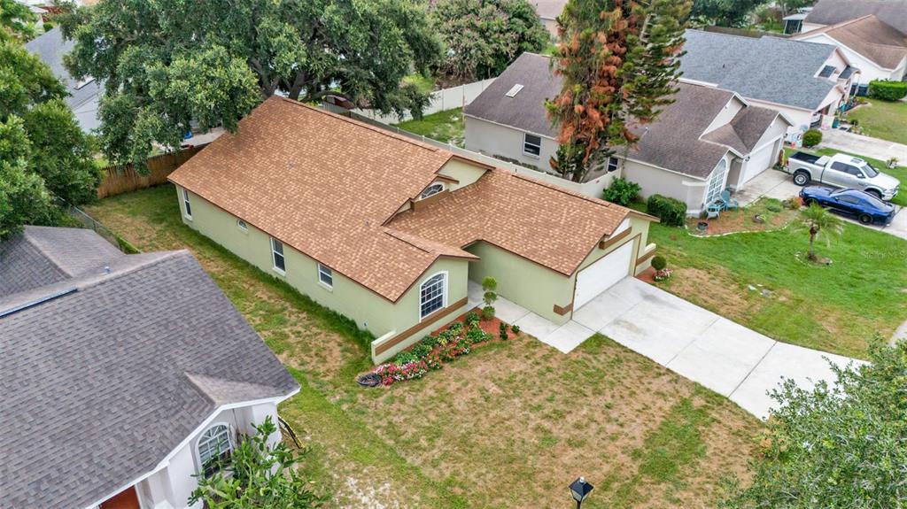 An aerial view of a light green house with a brown shingled roof and driveway — 419 SAINT ANNS DRIVE, WINTER HAVEN, FL