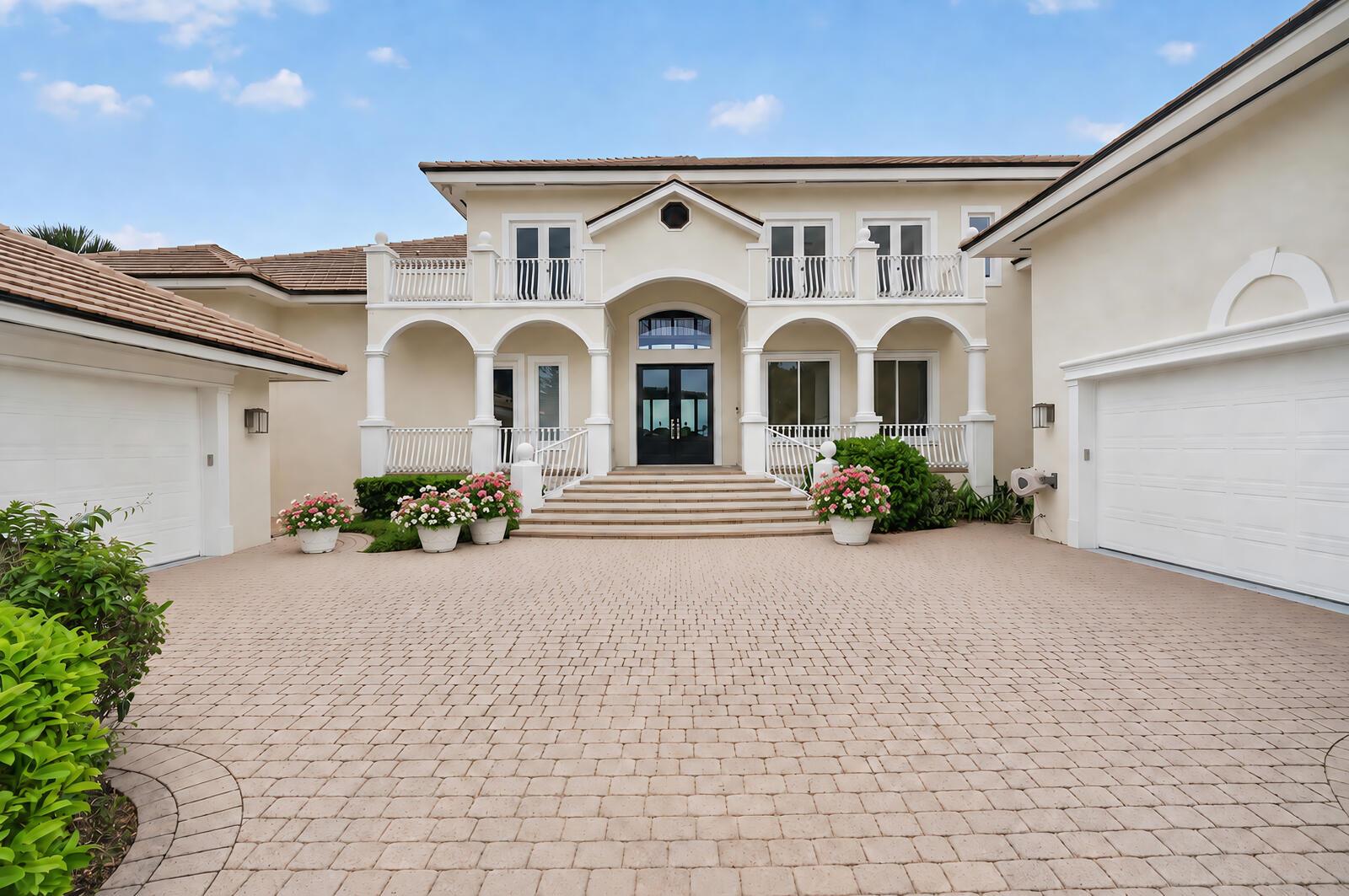 A two-story house with a paved driveway, two garages, and a central arched entryway — VERO BEACH, FL