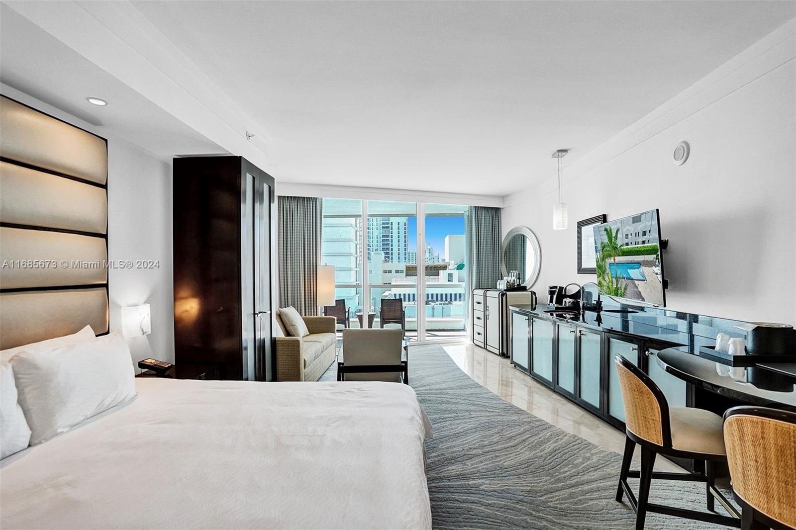 A modern hotel room features a bed, seating area, and a balcony with city views — 4391 Collins Ave # 915, Miami Beach FL 33140, MIAMI BEACH, FL