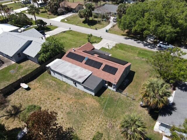 An aerial view shows a house with solar panels on its roof and a large yard — 4904 Myrtle Drive, Fort Pierce FL 34982, FORT PIERCE, FL