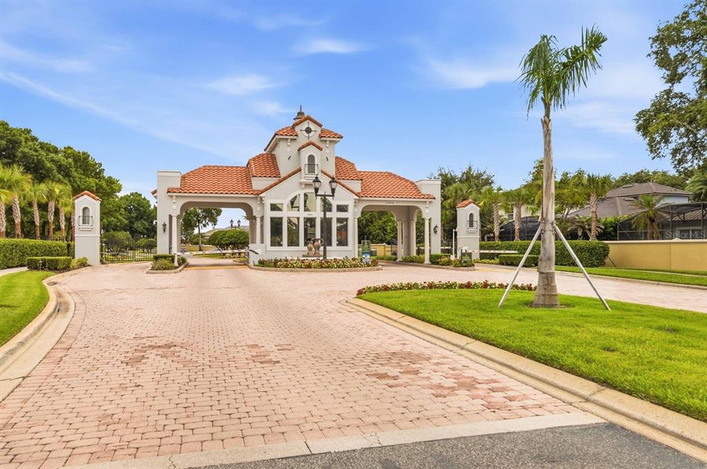 A two-story house with a tile roof, beige stucco exterior, and a paved driveway — 8310 TIVOLI DRIVE, ORLANDO, FL