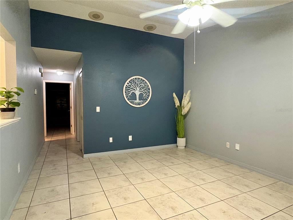 A room with tiled floors, a blue accent wall, and a ceiling fan — 1021 ALPUG AVENUE, OVIEDO, FL