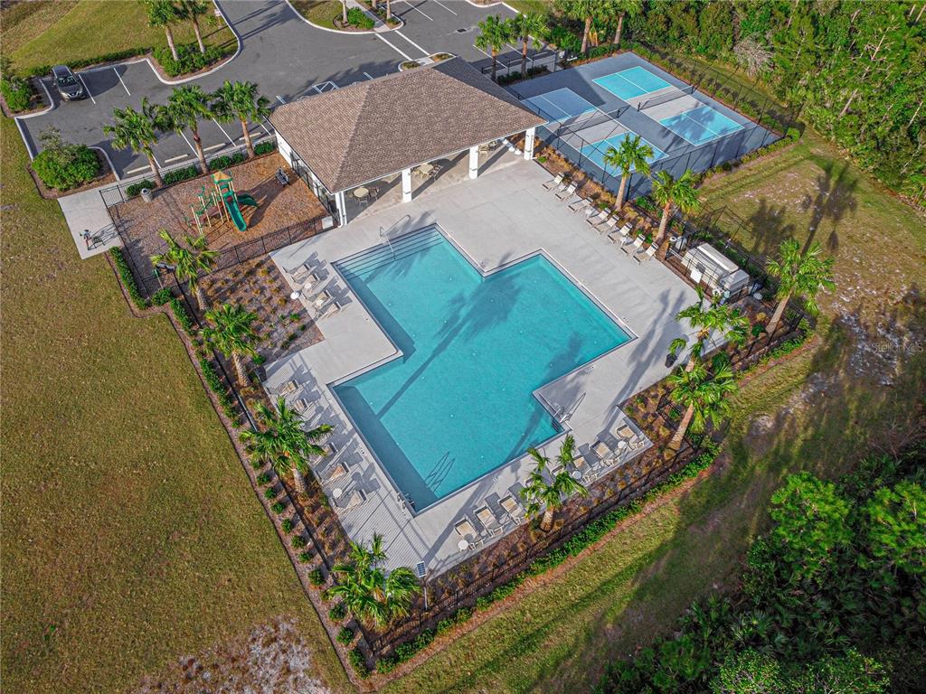 An aerial view shows a swimming pool, playground, and pickleball courts at a community facility — 2952 GIBRALTAR BOULEVARD, NEW SMYRNA BEACH, FL