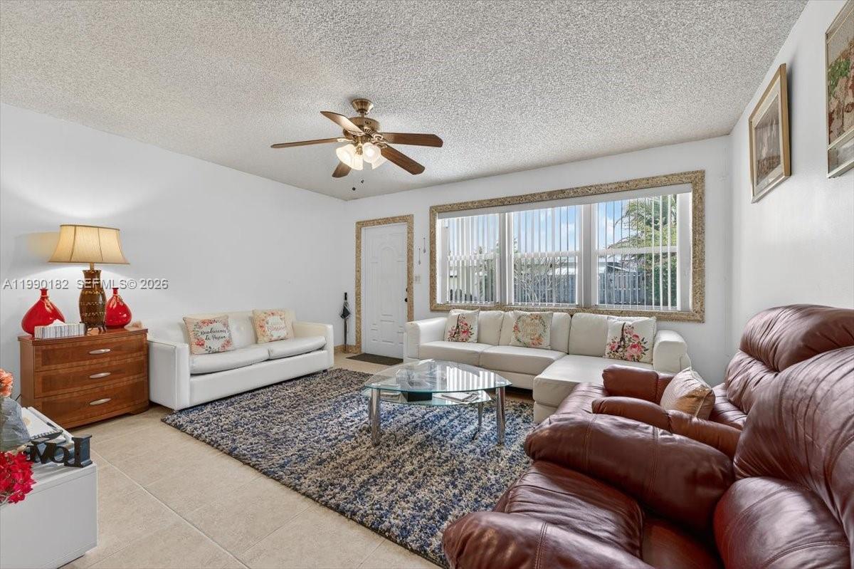 A living room features a white sofa, a brown leather recliner, and a large rug — 1125 NW 69th Ave, Margate FL 33063, MARGATE, FL