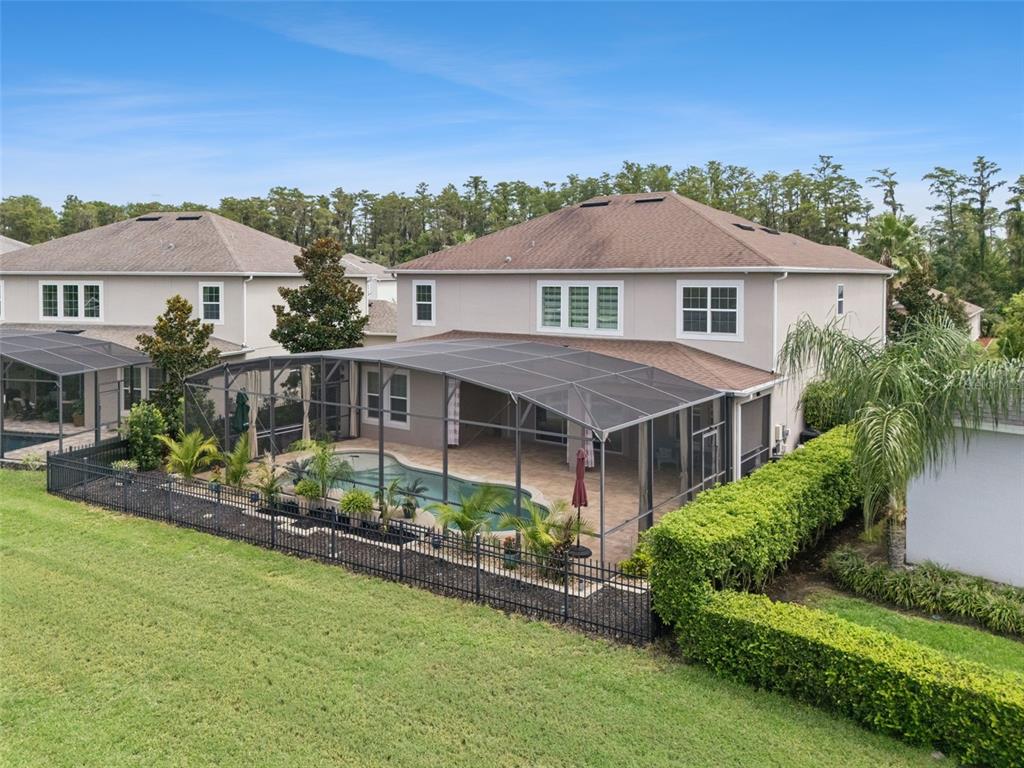 An aerial view shows a two-story house with a screened-in pool and a fenced backyard — 14038 JOMATT LOOP, WINTER GARDEN, FL