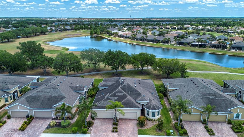 An aerial view shows a large pond surrounded by a golf course and residential homes — 804 CHIPPER DRIVE, SUN CITY CENTER, FL