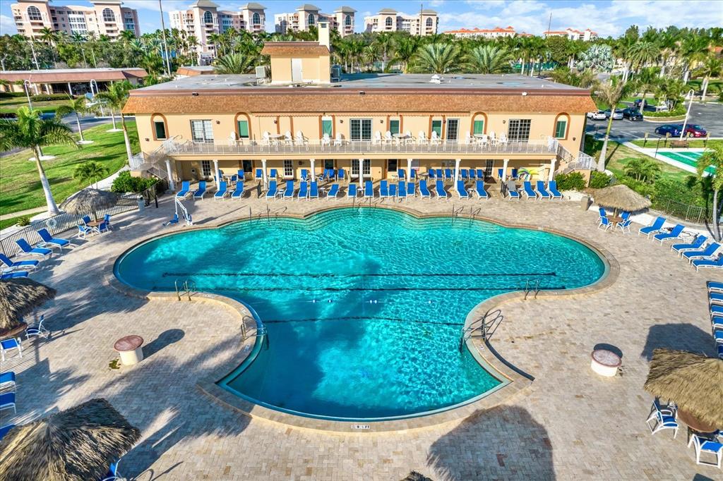 An aerial view of a large, irregularly shaped swimming pool with lounge chairs and umbrellas — 4900 BRITTANY DRIVE S UNIT 509, ST PETERSBURG, FL