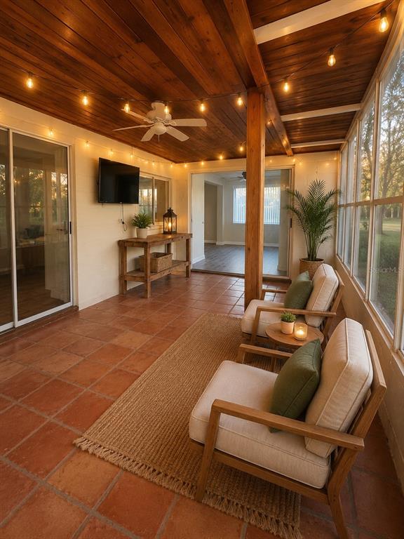 A covered patio features a wood ceiling, tile flooring, string lights, and two armchairs — 3507 LANDALE DRIVE, HOLIDAY, FL