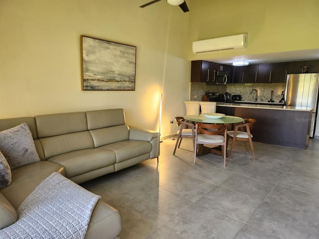 This open-concept living room features a leather sectional, a dining area, and a kitchen — 322 Beach Village BEACH VILLAGE - CANDELERO DRIVE - UNIT 322, HUMACAO, PR