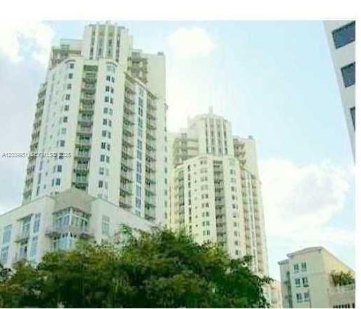 Exterior view of two tall, light-colored residential high-rise buildings against a blue sky — 9066 SW 73rd Ct # 1910, Miami FL 33156, MIAMI, FL