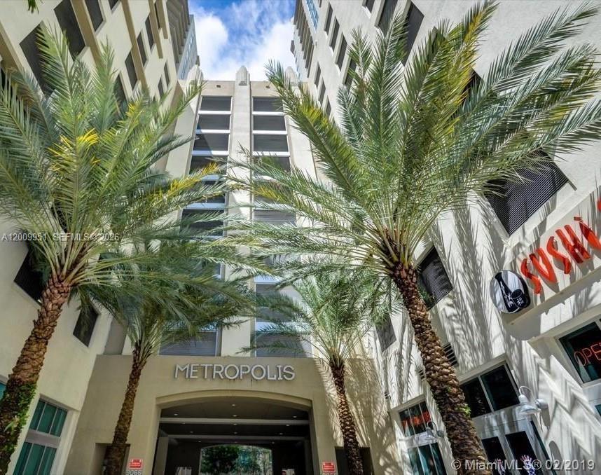 The exterior of the Metropolis building features a central entrance flanked by two tall palm trees — 9066 SW 73rd Ct # 1910, Miami FL 33156, MIAMI, FL