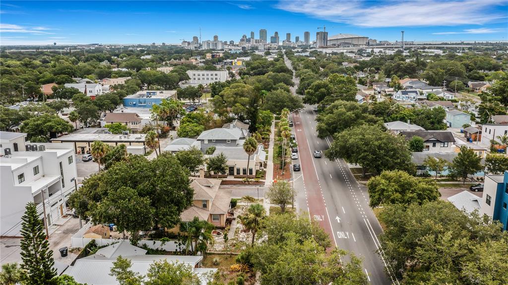 An aerial view shows a residential street with trees, houses, and a distant city skyline — 2701 1ST AVENUE S, ST PETERSBURG, FL