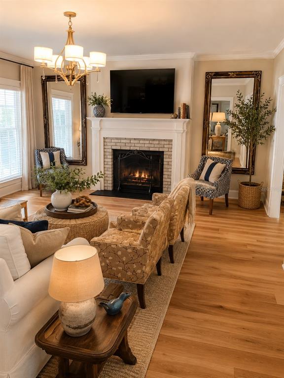 A living room features a fireplace, two large mirrors, patterned armchairs, and light wood flooring — 3922 NW 69TH STREET, GAINESVILLE, FL
